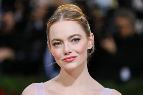 Emma Stone, con su color de pelo para ojos verdes, luce un peinado recogido y un maquillaje sutil.