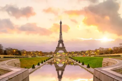 Tour Eiffel au coucher du soleil, reflet dans l'eau. Pensez au prix billet tour eiffel pour une visite inoubliable.