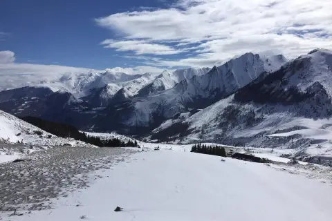 Vue panoramique depuis le col du Soulor, montagnes enneigées sous un ciel bleu et nuageux.
