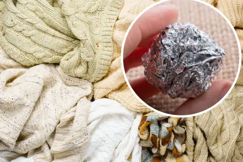 Kula z folii aluminiowej w dłoni, obok sterty sfilcowany sweter i inne dzianiny.