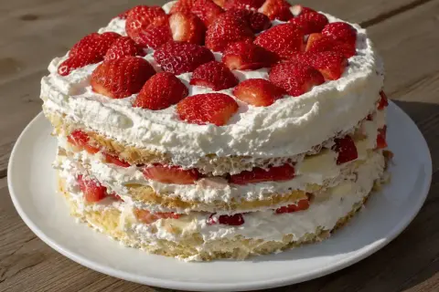 En vacker jordgubbstårta med fluffig grädde och saftiga jordgubbar. Perfekt att baka tårta till sommaren!