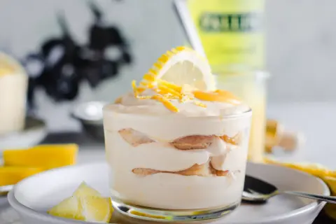 Un délicieux tiramisu limoncello, superposé de biscuits et de crème, garni d'une tranche de citron et de zestes.