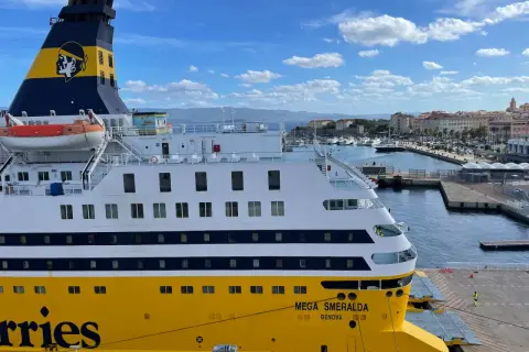 Le Mega Smeralda, un ferry de Corsica Ferries, est amarré dans un port pittoresque.