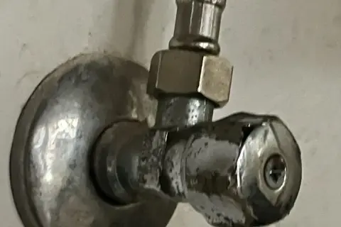 Metalowy zawór z widocznym uszkodzeniem. Może to być pomocne przy próbie jak wykręcić urwany zawór.