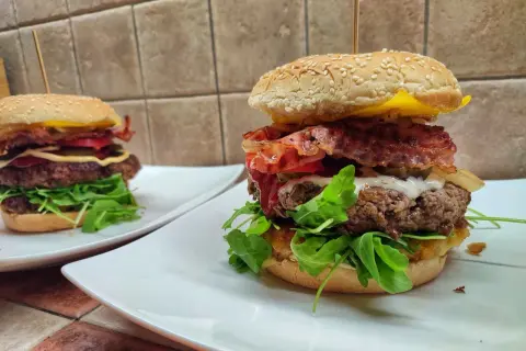 Dwa soczyste burgery wołowe z bekonem, serem i rukolą. Idealne, gdy zastanawiasz się, jak smażyć wołowinę na burgery.