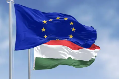 Flaga UE i Węgier powiewają na wietrze. Czy na Węgrzech można płacić euro? Oficjalnie nie, ale Unia Europejska to symbol wspólnoty.