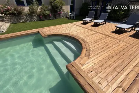 Terrasse en bois classe 3 ou 4, bordant une piscine aux eaux claires. Des chaises longues invitent à la détente sur ce bois chaleureux.