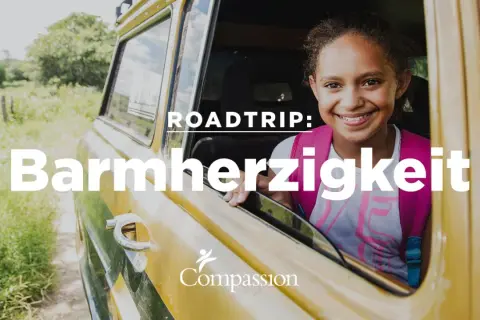 Ein lächelndes Mädchen im Auto, bereit für einen Roadtrip der Barmherzigkeit, inspiriert von Lukas 10, 25-37.