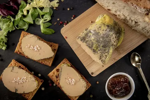 Tranches de foie gras sur toasts, accompagnées de pain frais, d'une compotée de fruits et d'une touche de cognac ou d'armagnac.