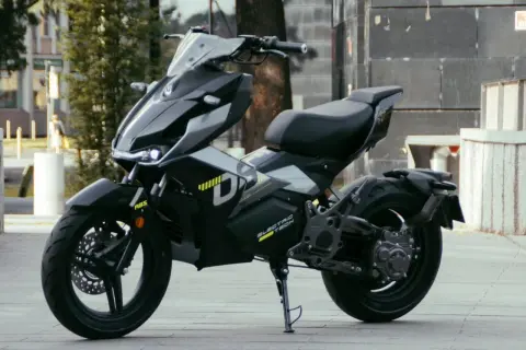 Moderna repro moto 125 eléctrica, negra y futurista, aparcada en la calle.