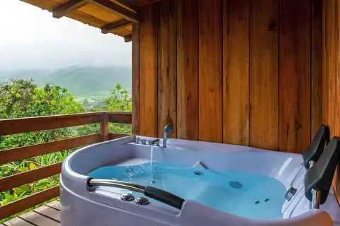A newly completed hot tub installation on a wooden deck, overlooking a misty mountain landscape.