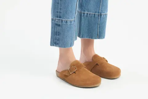 Brązowe zamszowe klapki z klamrą idealnie pasują do jeansów mom. Stylowe i wygodne buty na co dzień.