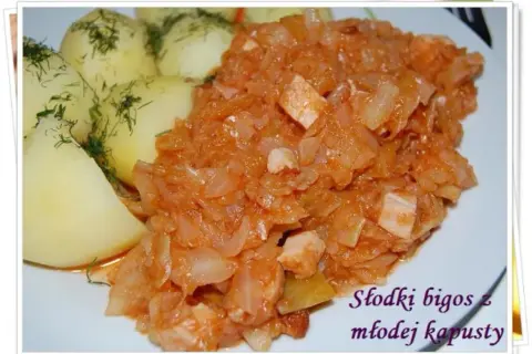 Słodki bigos z młodej kapusty, duszony z mięsem, podany z ziemniakami i koperkiem. Idealny przepis na letni obiad.