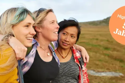 Drei Freundinnen genießen die Natur. Ihre Freundschaft zeigt sich in der Nähe und dem Lachen.
