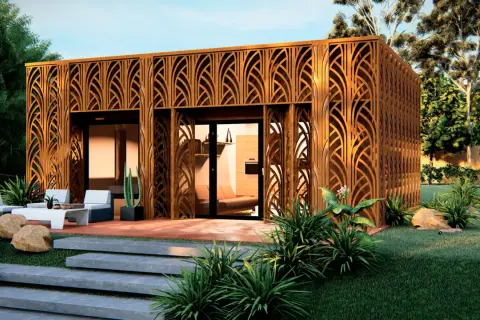 Moderna pared prefabricada exterior con diseño de celosía de madera, rodeada de vegetación y un área de descanso.