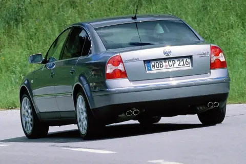 Srebrny Volkswagen Passat, wyglądający jak sleeper car, jedzie po drodze.