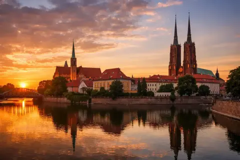 Zachód słońca nad Odrą we Wrocławiu, województwo. Katedra i zabytkowe budynki odbijają się w wodzie.