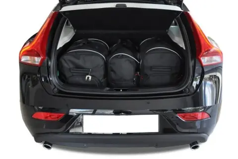 Tre svarta resväskor fyllda i volvo v40 bagageutrymme. Perfekt för en weekendresa!