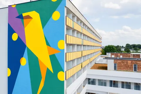 Kolorowy mural z ptakiem zdobi ścianę sanatorium milicyjnego w Nałęczowie.