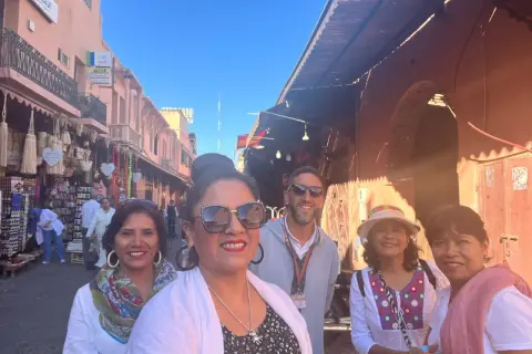 Grupo de mujeres sonríe en un mercado de Marruecos. Viajar a Marruecos es peligroso para mujeres, pero ellas disfrutan la aventura.
