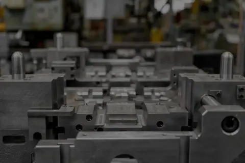 Precyzyjna budowa form wtryskowych w zakładzie produkcyjnym. Metalowe elementy tworzą skomplikowaną strukturę gotową do pracy.