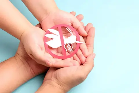 Dłonie trzymają symbol komara przekreślonego na czerwono. Zastanawiasz się nad malarone skutki uboczne?