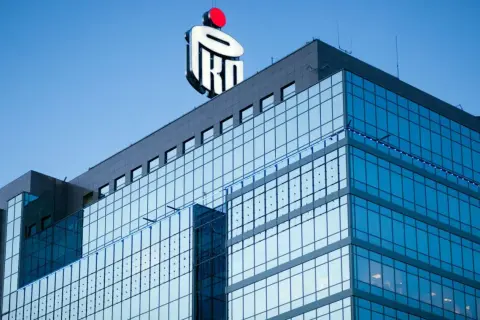 Nowoczesny budynek PKO BP z charakterystycznym logo. Myśląc o wakacjach kredytowych, warto pamiętać o tej instytucji.