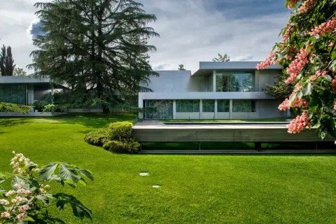 Modern villa con piscina y jardines impecables, un ejemplo de patios de lujo.