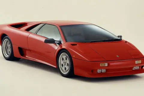 Czerwony Lamborghini Diablo, ikona lat 90., prezentuje swoje ostre linie i sportowy profil.