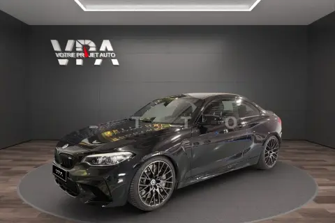 Une BMW M2 Competition noire, prête à rugir comme un pur-sang. Ses lignes agressives promettent une expérience de conduite d'exception.