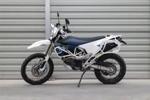 Motocykl enduro Husqvarna 701 z bagażnikiem i osłonami.