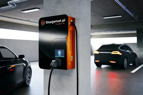 Nowoczesna ładowarka Stacjomat.pl w garażu podziemnym. Samochód elektryczny czeka na podłączenie, zgodnie z przepisami.