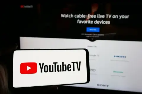 Smartfon z logo YouTube TV na tle ekranu telewizora z napisem "Watch cable-free live TV". Aktualizacja YouTube za darmo to świetna opcja.