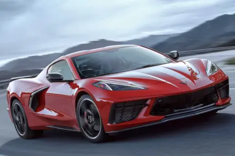Czerwony Chevrolet Corvette C8 pędzi po krętej drodze. Sprawdź aktualną corvette c8 cena i marzenia o tym aucie.