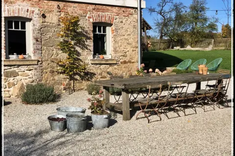 Rusty metal chairs await guests at a rustic table outside a stone building. Ideal agroturystyka Dolny Śląsk.