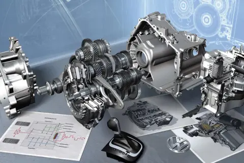Rozłożona skrzynia DSG z widocznymi biegami, wałkami i schematem technicznym. Obok leży selektor biegów i logo VW.