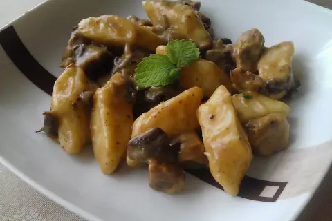 Pyszne kopytka w kremowym sosie grzybowym, udekorowane listkiem mięty. Idealny sos do kopytek na obiad.