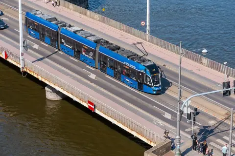 Blauer Straßenbahnzug fährt über eine Brücke, auf dem Weg von Görlitz nach Breslau.