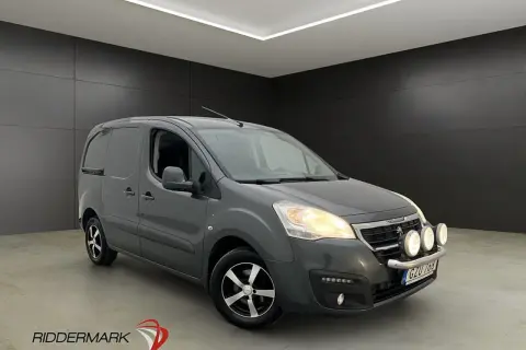 Grå Peugeot Partner skåpbil med extraljus. Tänk på peugeot kamremsbyte intervall för att hålla den i toppskick.