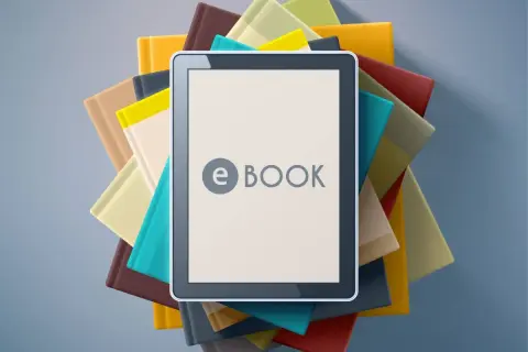 Une tablette affiche "e BOOK" au milieu d'une pile de livres colorés. C'est quoi un ebook ? Une nouvelle façon de lire !