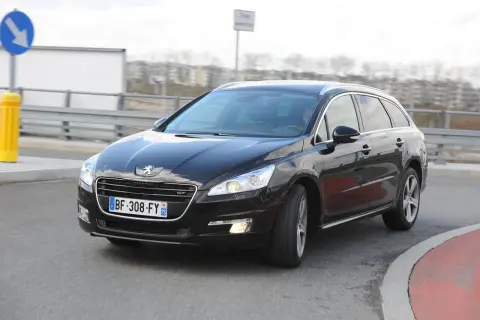 Czarny Peugeot 508 GT na drodze, przygotowany do wymiany żarówki z przodu.