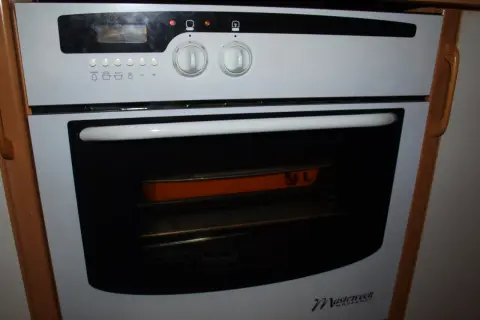Piekarnik Mastercook z pomarańczową brytfanną w środku. Dowiedz się, jak zresetować piekarnik Mastercook, gdy coś pójdzie nie tak.