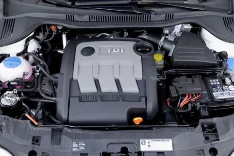 Silnik 1.4 TDI z widocznym napisem TDI na pokrywie. Widać elementy układu chłodzenia, akumulator i przewody.
