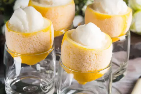 Erfrischendes Sorbetto al limone, serviert in ausgehöhlten Zitronen, die in Gläsern stehen.