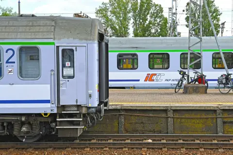 Nowe wagony PKP Intercity z zielonym pasem czekają na pasażerów. Na peronie stoją rowery.