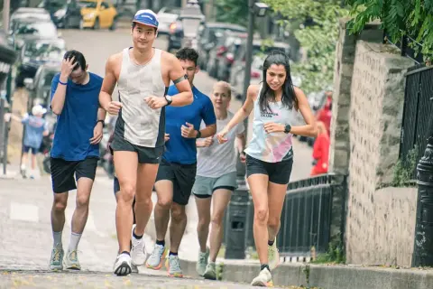 Un groupe de coureurs s'entraîne dans les rues pavées, une course qui rappelle une **corrida auch** par son énergie.