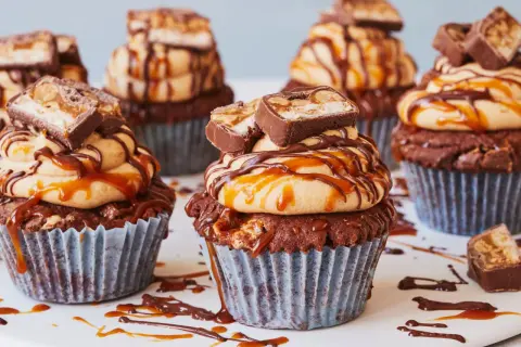 Schokoladen-Muffins mit Erdnussbutter-Frosting, Karamell und Snickers-Stücken. Diese Snickers Muffins sind ein Traum!