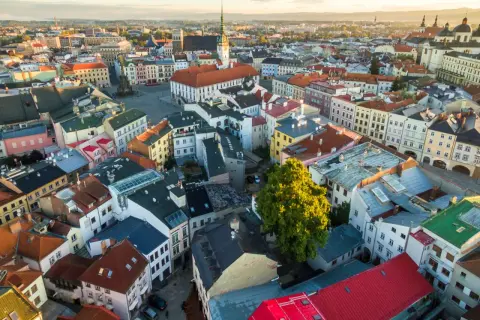 Blick über die Dächer von Olomouc, Tschechien, im goldenen Licht der Abendsonne. Bunte Häuser und historische Gebäude prägen das Stadtbild.