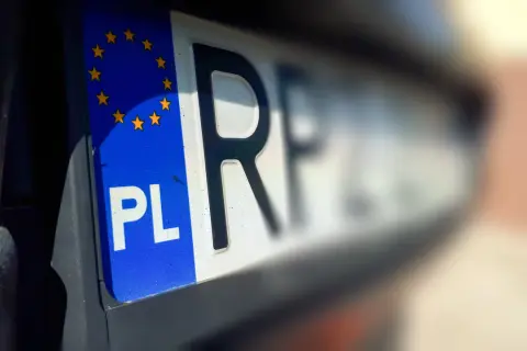 Zbliżenie na polską tablicę rejestracyjną z symbolem UE. Szybkie wyrejestrowanie auta online jest teraz możliwe.