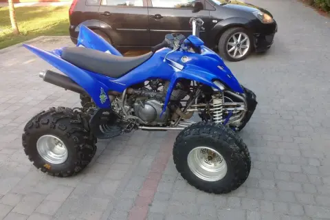 Niebieski Yamaha Raptor 350, quad z mocnym silnikiem, gotowy do jazdy. Ile ma koni? To pytanie dla fanów off-roadu!